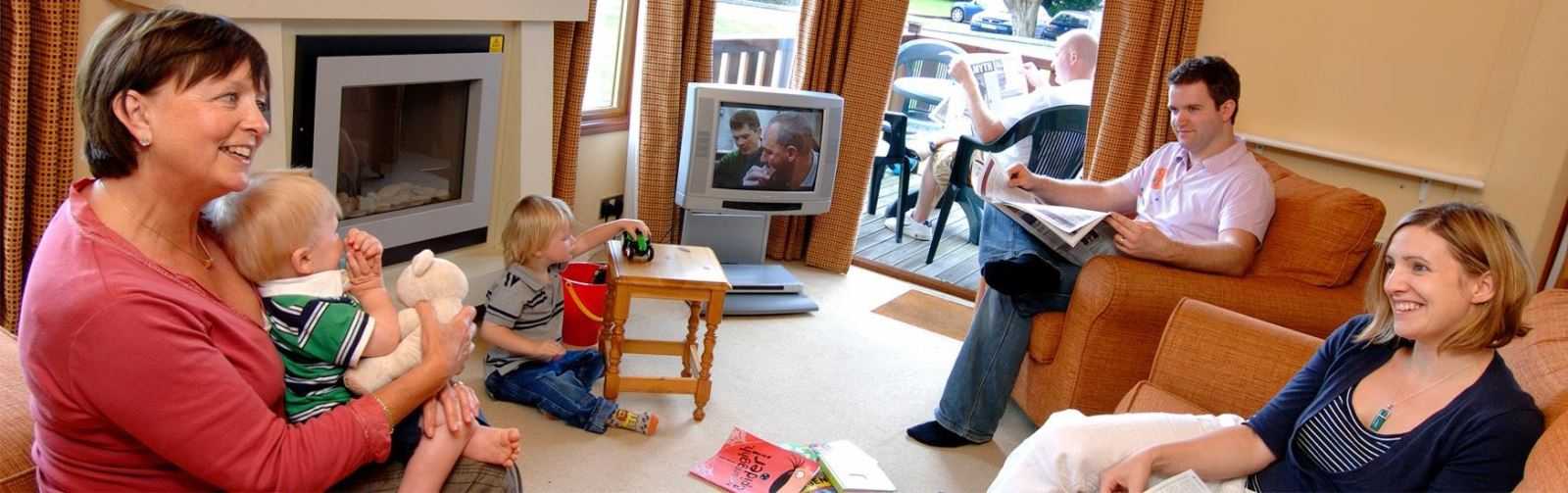 Family relaxing in the lounge of their holiday accommodation 